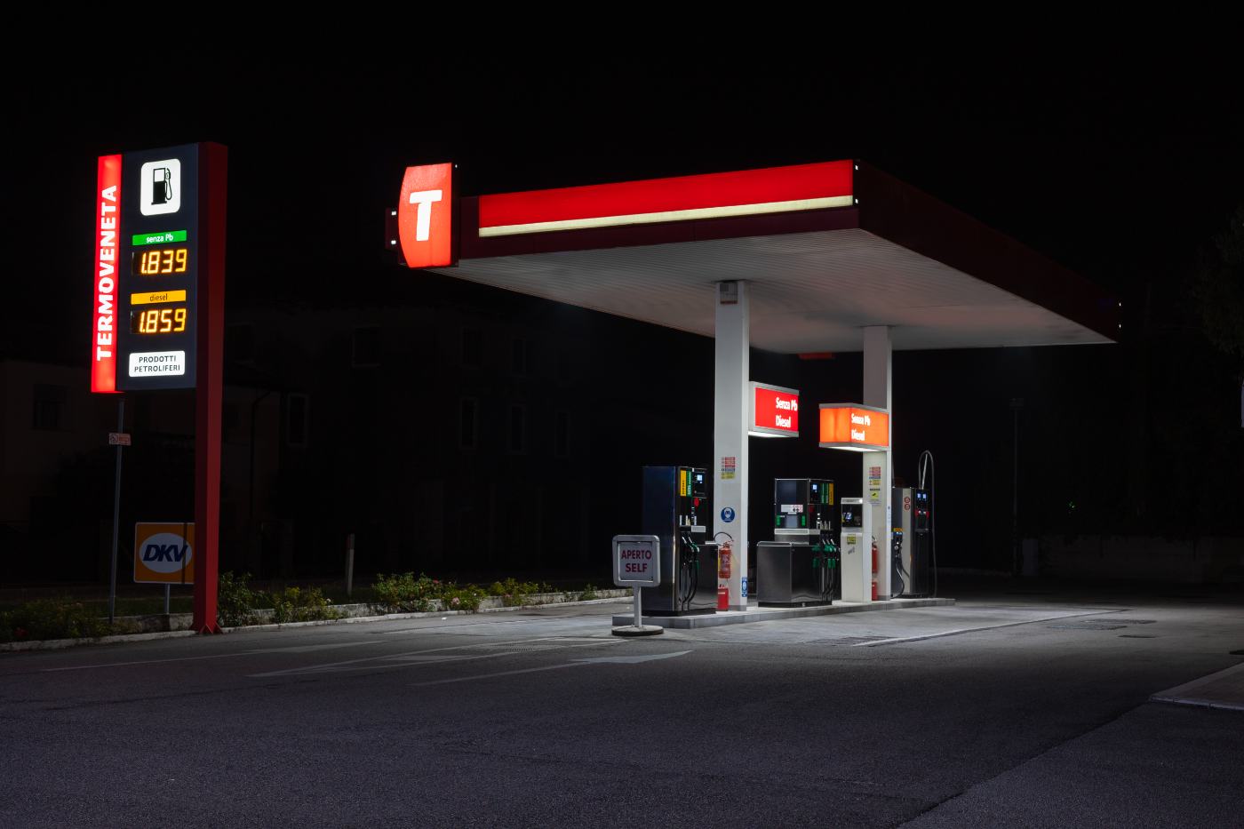 Distributore di benzina fotografato di notte, insegna illuminata