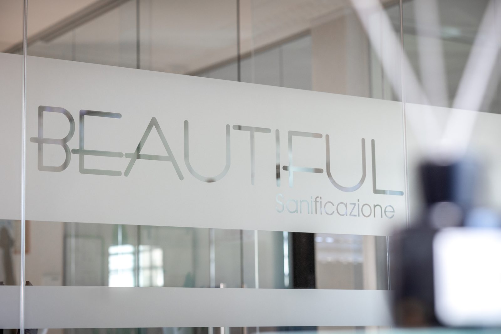 Logo Beautiful Sanificazione inciso sulla vetrata dell'ufficio