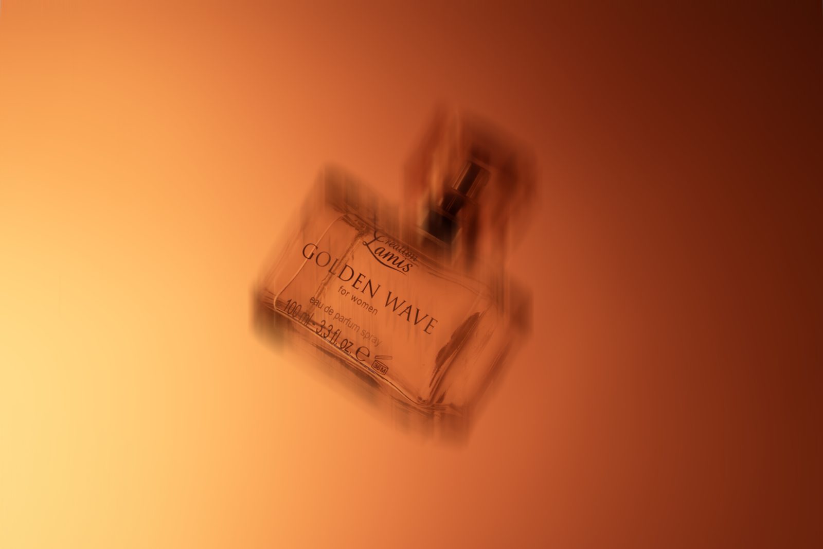 Still life di una boccetta di profumo su fondo arancione sfumato
